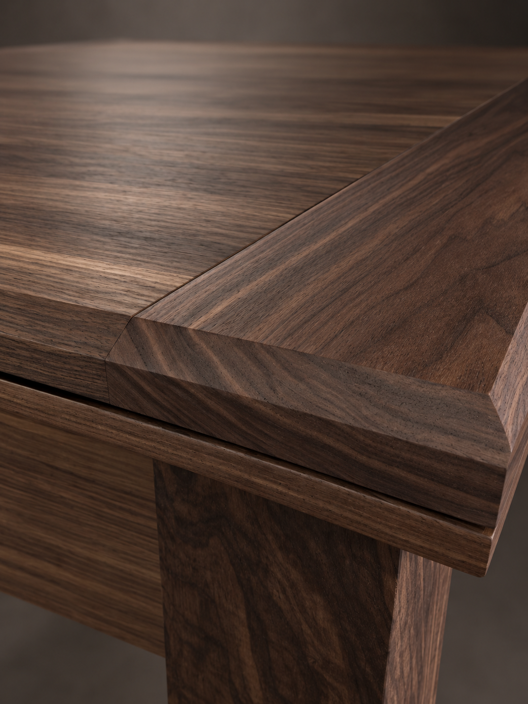 Low-angle detail of SIEGE walnut leg and shaped apron